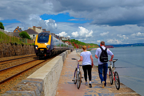 Walking with bikes by a train