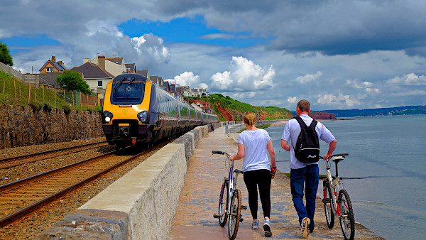 Walking with bikes by a train