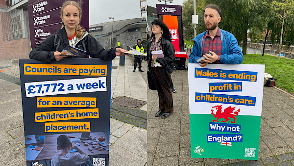 Image of campaigners carrying boards that say "Councils are paying £7772 a week for an average children's home placement" and "Wales is ending profit in children's care. Why not England?"