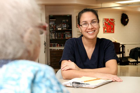 Photo of care assistant talking to older person