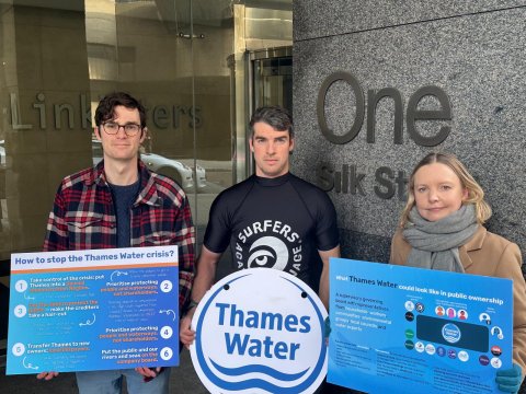 Imamge shows three protestors outside Linklatters law offices holding boards presenting information on what should happen next to Thames Water