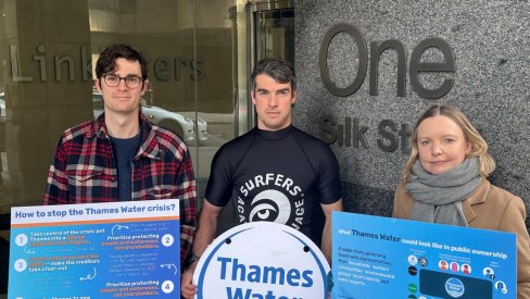 Imamge shows three protestors outside Linklatters law offices holding boards presenting information on what should happen next to Thames Water