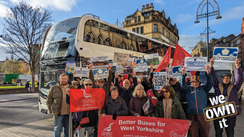 Campaigners at a demonstration to bring buses in West Yorkshire under public control, in front of a bus