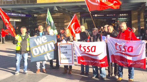 campaigners outside Kings Cross holding flags, banners and the stop look listen placard