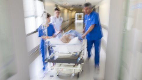 Hospitals staff pull along a bed